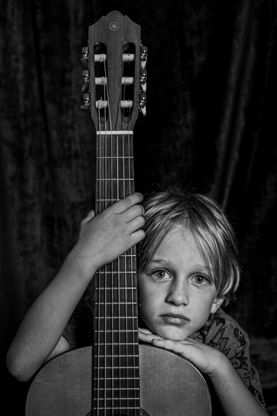 a boy with his chin on his guitar