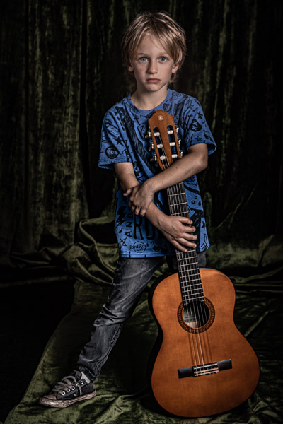 a boy standing with his guitar