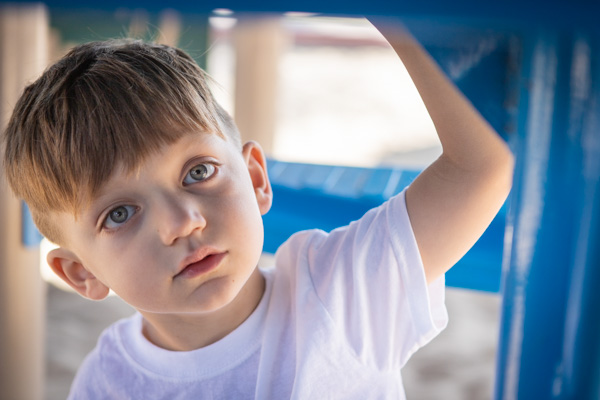 a boy under a playground apparatus